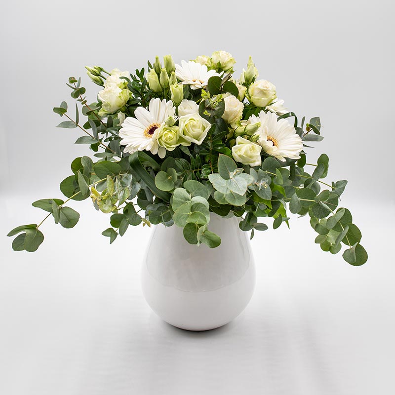 Escapade lumineuse Bouquet composé de fleurs blanches de saison telles les roses et gerberas