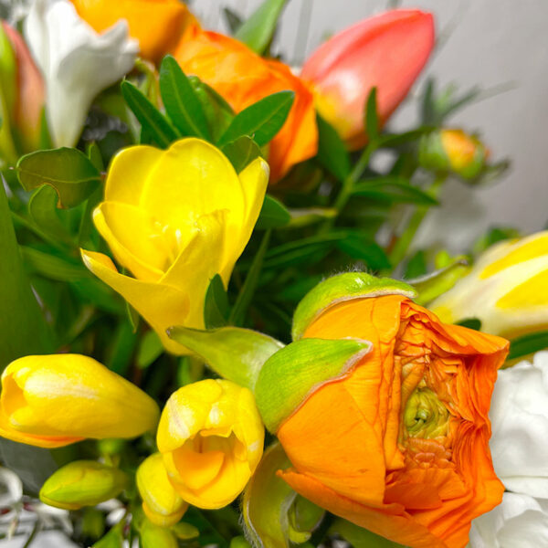 Le printanier bouquet champêtre de fleurs de saison freesias tulipes renoncules
